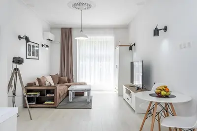a white living room with a couch and a table at Jazz & Wine - Luxury apARTment By The Sea & Parking & HBO & Netflix in Varna City