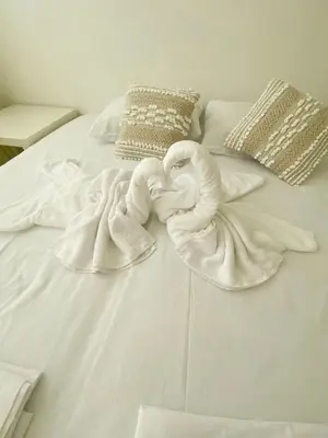 a white bed with towels and pillows on it at Luxury First Line apartment with pool by the sea in Nesebar