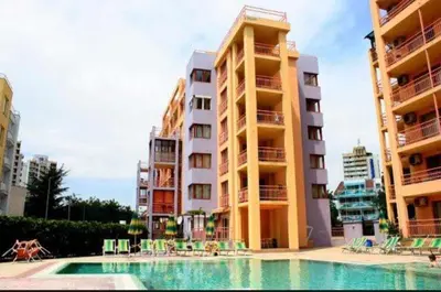 a hotel with a swimming pool in front of two buildings at Апартамент Златна дюна-Фешева in Nesebar