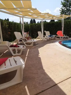 a group of chairs and a pool with umbrellas at Studio VIP-ZONE in Sunny Beach