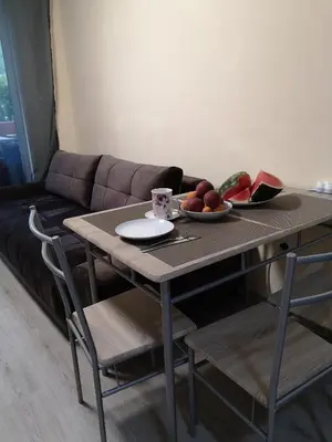 a table with a bowl of fruit and a couch at Studio VIP-ZONE in Sunny Beach