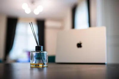 a bottle on a table next to a laptop computer at Smart Central Apartment in Varna City
