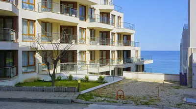 an apartment building with the ocean in the background at Byala Vista Beach Apartments D - Бяла Виста Бийч Апартментс Д in Byala