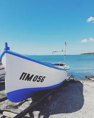 a boat sitting on the shore of a beach at Апартамент Иванови in Pomorie