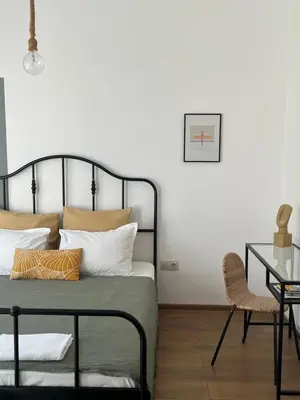 a bedroom with a bed with pillows and a table at Atelier 26 in Varna City