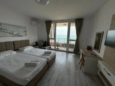 a bedroom with a large bed with a view of the ocean at Апартаменти за гости 