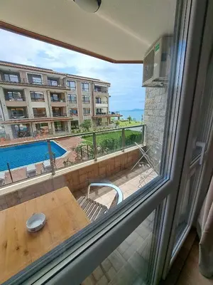 a balcony with a table and a view of a building at Апартаменти за гости 