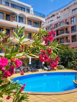 a pool in front of a building with pink flowers at Apartment Casa del Mar (Dinevi Resort) in Sveti Vlas