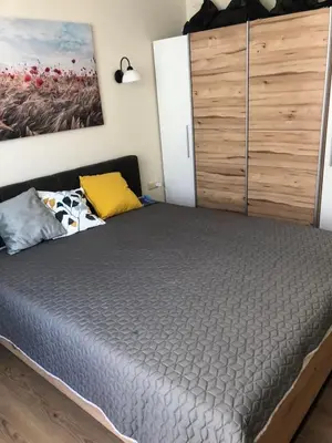 a bed in a room with a wooden cabinet at Rich-2 SP apartments in Ravda