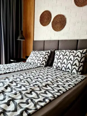 a bed with a black and white comforter and pillows at Studio Greenn Life Beach Resort in Sozopol