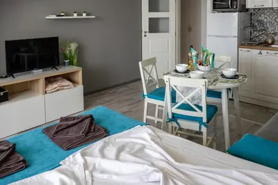 a living room with a bed and a table with chairs at A-33-Sea View Studio Apartment Sarafovo in Burgas City