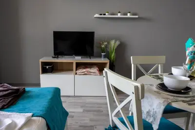 a living room with a tv and a table with chairs at A-33-Sea View Studio Apartment Sarafovo in Burgas City