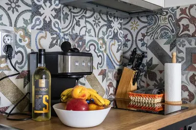 a bowl of fruit on a counter with a bottle of wine at A-33-Sea View Studio Apartment Sarafovo in Burgas City