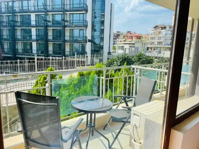 a balcony with a table and chairs and a view of a city at Apartament in sun waves in Burgas City
