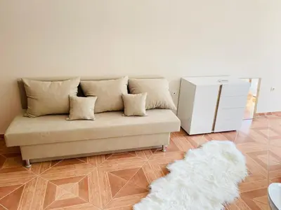 a living room with a couch and a white rug at Apartament in sun waves in Burgas City