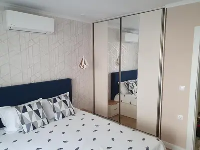a bedroom with a bed with a blue headboard at Sarafovo Sea Star in Burgas City