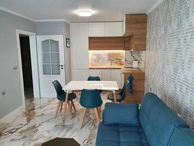 a living room with a blue couch and a table and chairs at Sarafovo Sea Star in Burgas City