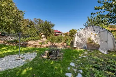 a garden with a small greenhouse in the grass at Villa Viara in Pchelnik
