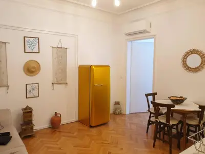 a room with a yellow refrigerator and a table at Апартамент BOHO CHIC Free parking in Varna City