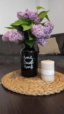 a black vase with purple flowers on a table at Apartment Lazur Karlovo 8 street free parking in Burgas City