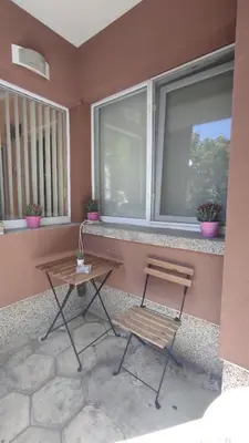 a table and two chairs on a balcony with windows at Apartment Lazur Karlovo 8 street free parking in Burgas City