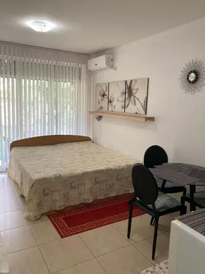 a bedroom with a bed and a table and chairs at Уютная квартира - студия в Старом Поморие, Болгария in Pomorie