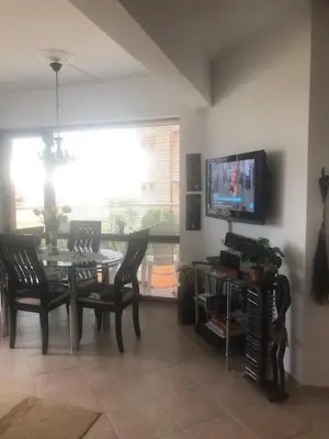 a dining room with a table and chairs and a tv at Ravda Sun Sea Ressort 2 in Ravda