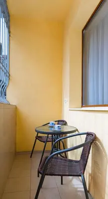 a table and a chair next to a yellow wall at Студио Булаир 1 с безплатен паркинг in Burgas City