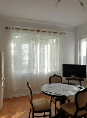 a living room with a table and chairs and a television at Апартамент BOHO CHIC 2 Free parking in Varna City