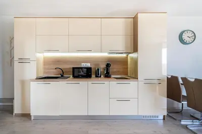 a kitchen with white cabinets and a microwave at Premium complex Millennium 2 - Family apartment & Spa in Sveti Vlas