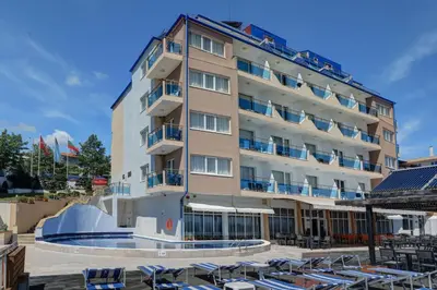 a hotel with lounge chairs in front of a pool at Paraiso Beach - All Inclusive in Obzor