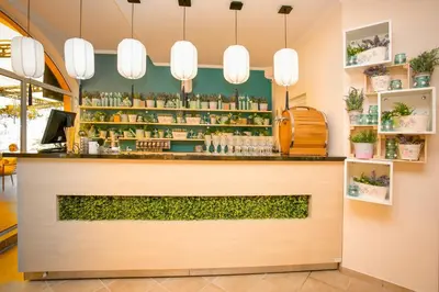 a bar at a restaurant with plants at Touristic Complex Hacienda Beach Apartments Sozopol in Sozopol