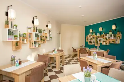 a restaurant with tables and chairs and green walls at Touristic Complex Hacienda Beach Apartments Sozopol in Sozopol