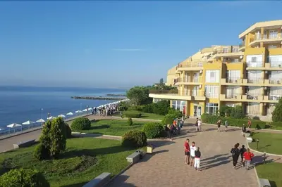 a group of people walking down a sidewalk next to a building at Midia Grand Resort, Terrassen Paradies Apartment in Aheloy