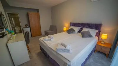 a bedroom with a large bed with two pillows on it at La Mansión in Lozenets