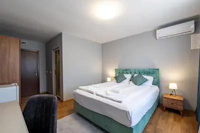 a bedroom with a large bed with a blue headboard at La Mansión in Lozenets