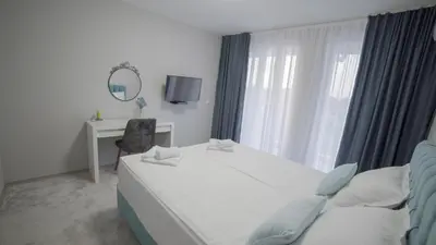a bedroom with a bed and a desk and a mirror at La Mansión in Lozenets