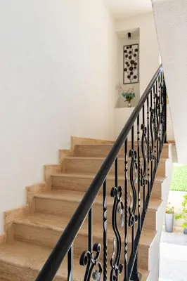 a staircase with wooden stairs and a black railing at La Mansión in Lozenets