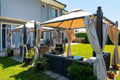 a patio with an umbrella in a yard at La Mansión in Lozenets