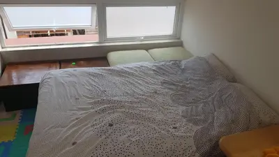 a bed sitting in a room with two windows at The Penthouse in Varna City