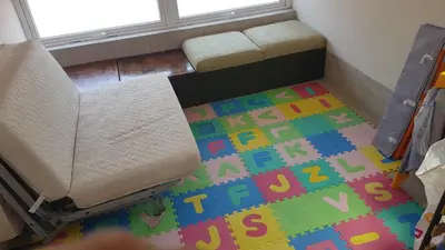 a living room with a couch on a colorful rug at The Penthouse in Varna City