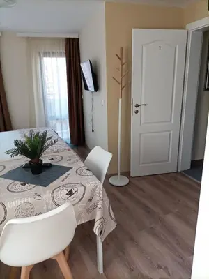a dining room with a table and white chairs at DAMARIS in Sozopol