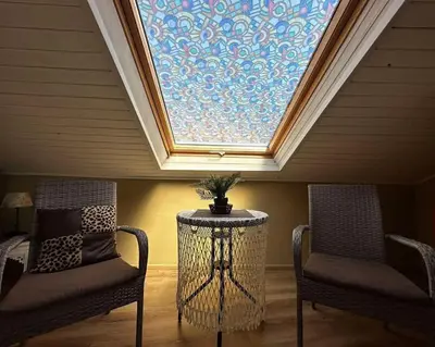 two chairs and a table in a room with a skylight at DAMARIS in Sozopol