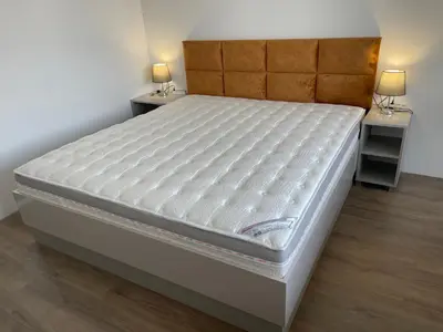 a bed in a room with two night stands at DeTY's Apartment in Burgas City