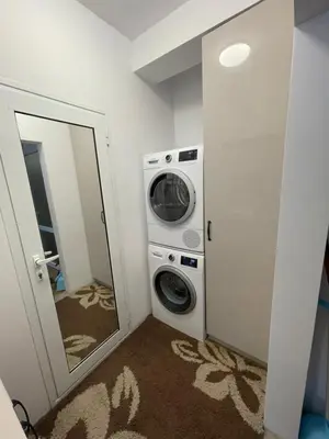 a laundry room with a washing machine and a mirror at DeTY's Apartment in Burgas City