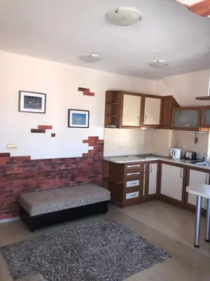 a kitchen with a brick wall and a bench in it at Dunav Apt.4 in Ravda