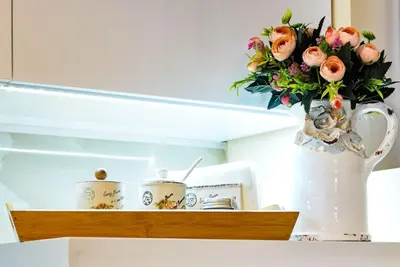 a vase filled with flowers on a shelf in a kitchen at CASA ARTA in Burgas City