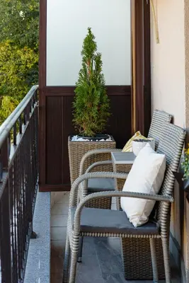 two wicker chairs and a table on a balcony at CASA ARTA in Burgas City