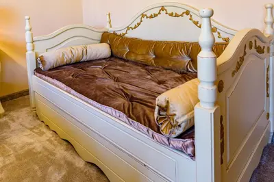a bed with a white frame and a brown couch at CASA ARTA in Burgas City