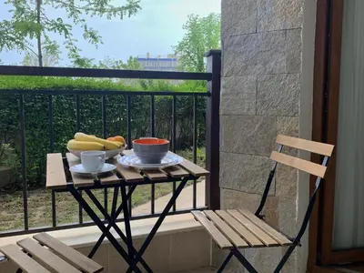 a table with a plate of fruit on a balcony at Бяла Виста Бийч Апартментс B - Byala Vista Beach Apartments B in Byala